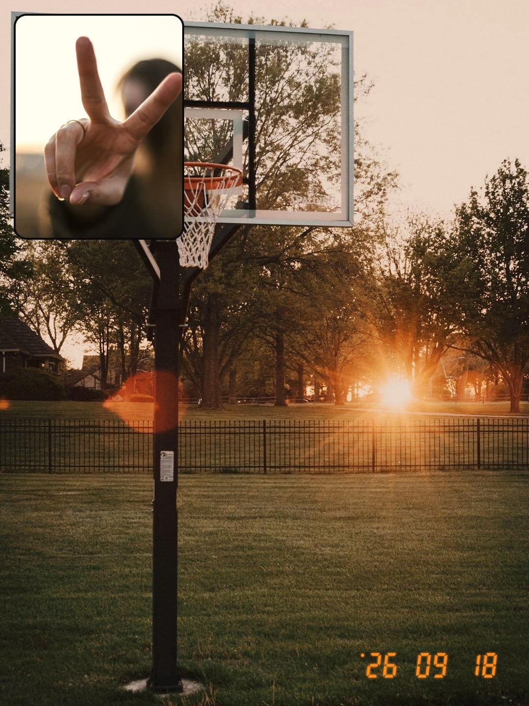 Back camera: a basketball hoop at sunset. Selfie inset: a peace sign.