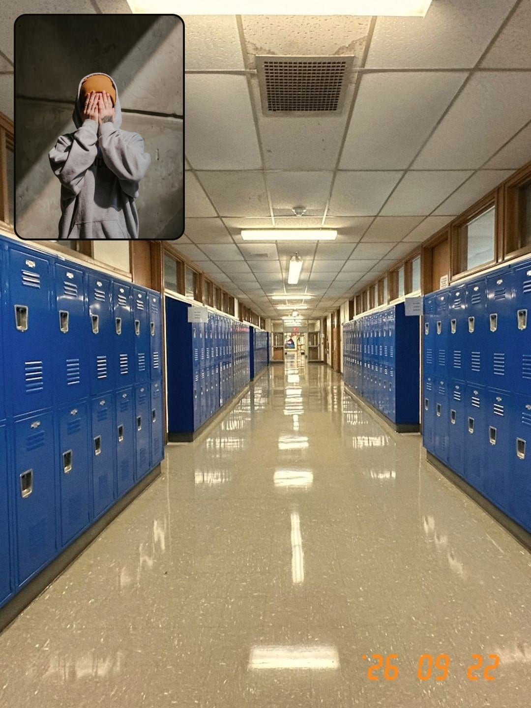 Back camera: an empty school hallway lined with blue lockers. Selfie inset: hands over a face.